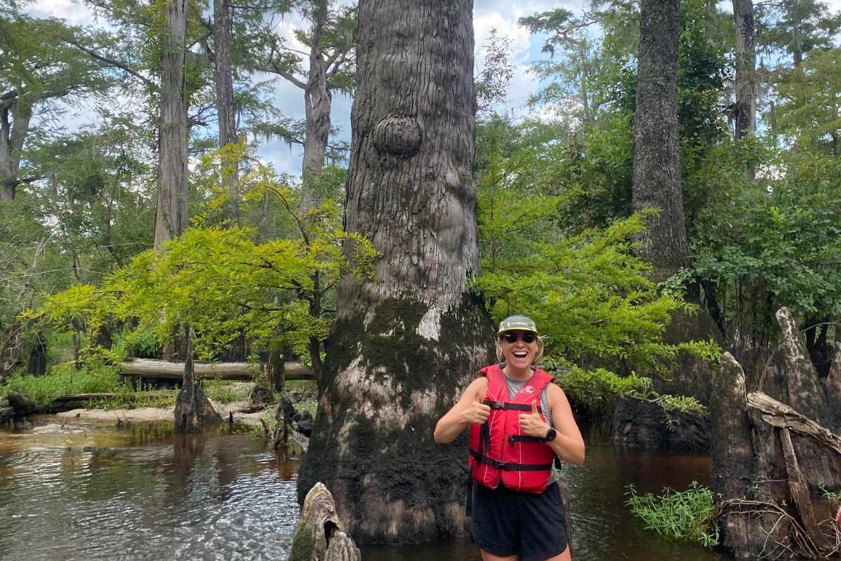 Sam Burton is smiling in front of a tree in the Black River.